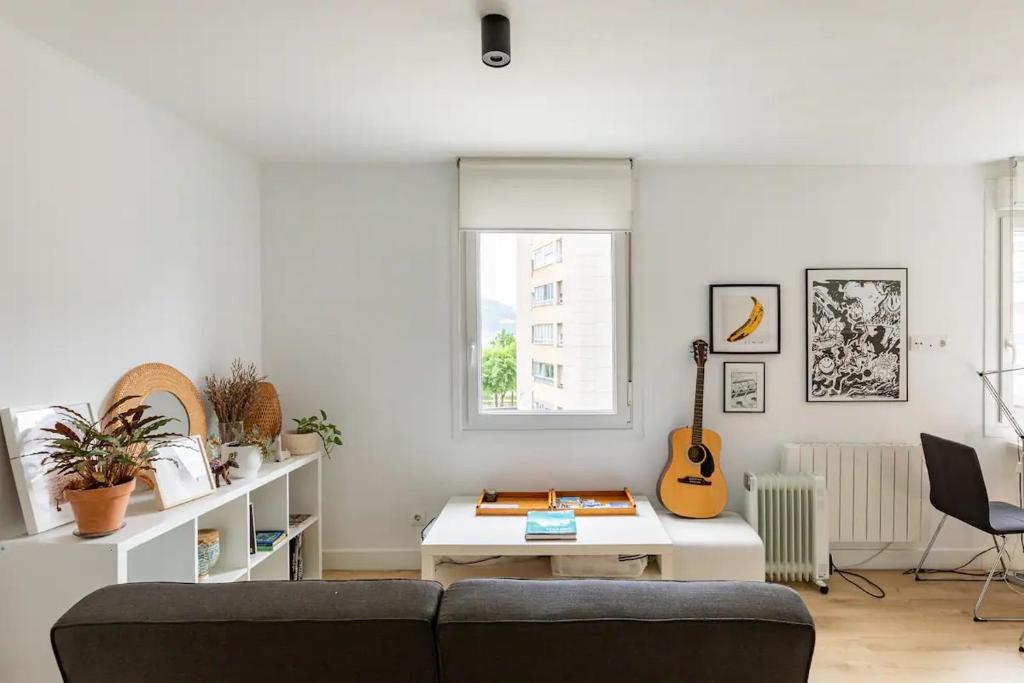 a living room with a couch and a guitar at 10m Casco Viejo in Bilbao