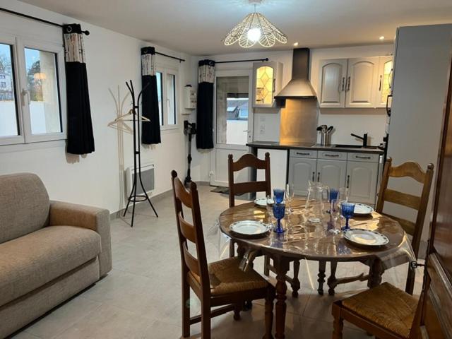 un salon avec une table et des chaises et une cuisine dans l'établissement Chez JP, à Saint-Côme-de-Fresné