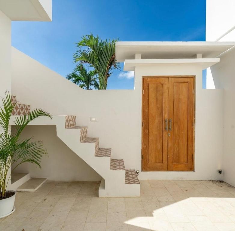 eine Treppe, die zu einem Haus mit einer Holztür führt in der Unterkunft Villa Ben Uluwatu in Uluwatu