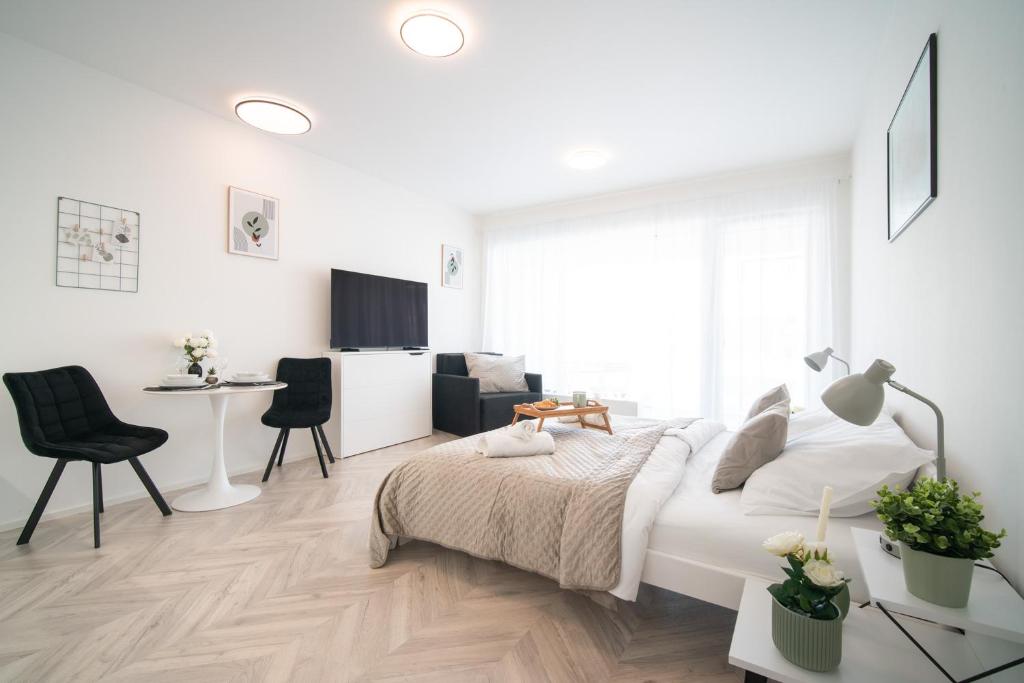 a white bedroom with a bed and a desk at apartino - FREE parking, 10 minutes walk to city centre, nespresso, netflix in Brno