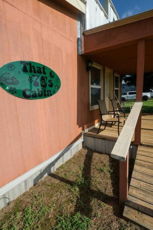 a porch with a surfboard on the side of a house at That 70s Cabin Yellow Rose Canyon in Mount Enterprise
