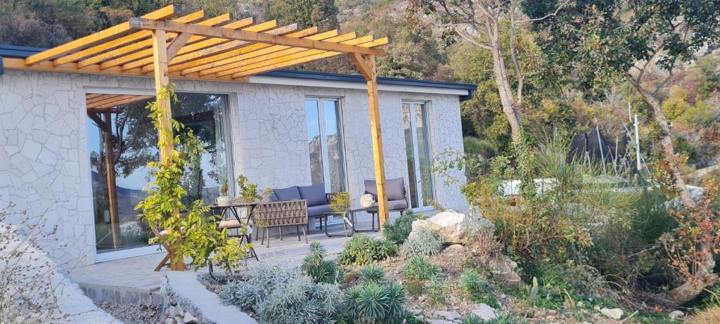 a home with a wooden pergola and a patio at Sunrise Lodge in Dapčevići
