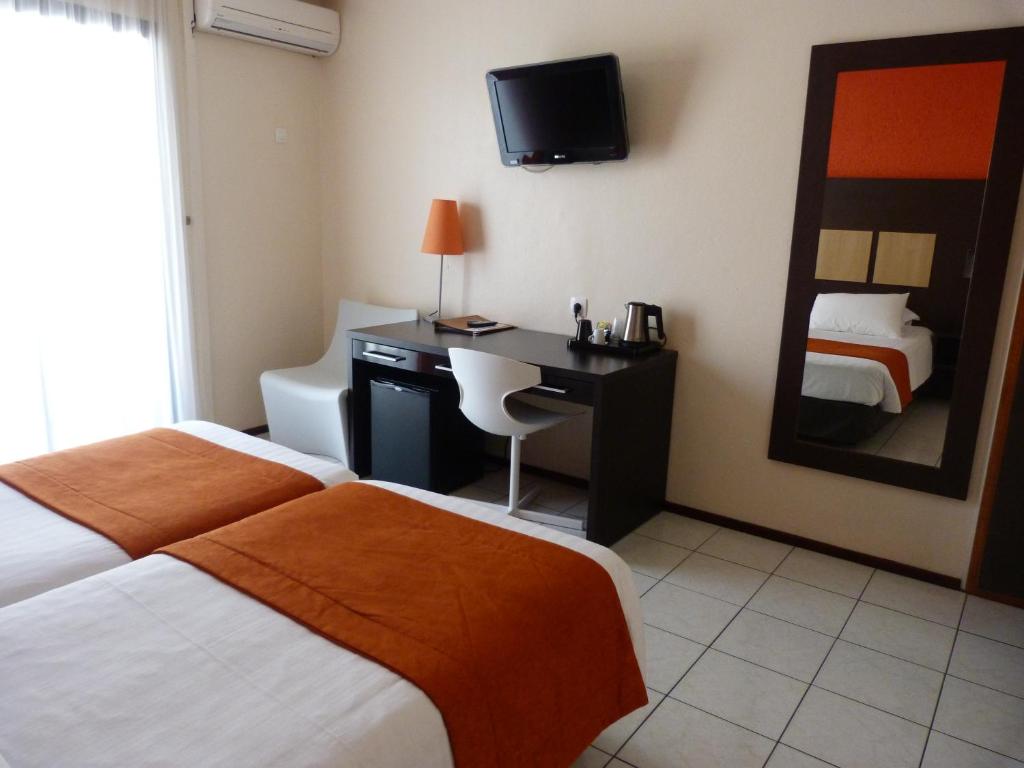 Postel nebo postele na pokoji v ubytování Central Hotel Cayenne