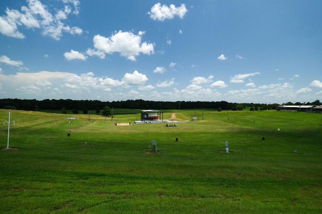 a large field with a tent in the middle of it at Willie's Cabin Yellow Rose Canyon in Mount Enterprise