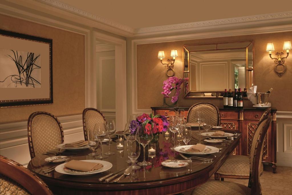 a dining room with a table with chairs and a mirror at The Ritz-Carlton New York, Central Park in New York