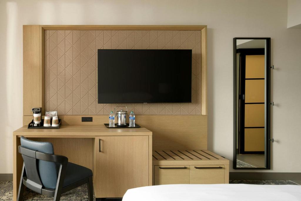 a bedroom with a desk and a television on a wall at Sheraton Park Hotel at the Anaheim Resort in Anaheim