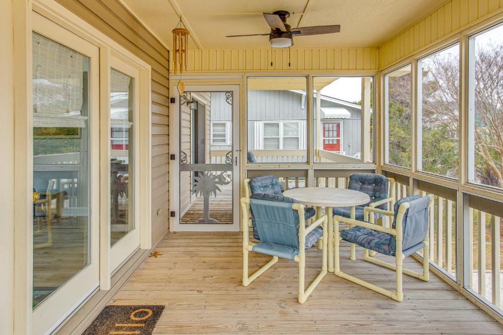 une véranda avec une moustiquaire, une table, des chaises et des fenêtres dans l'établissement Walk to Ocean Sunset Beach House with 3-Level Deck!, à Sunset Beach