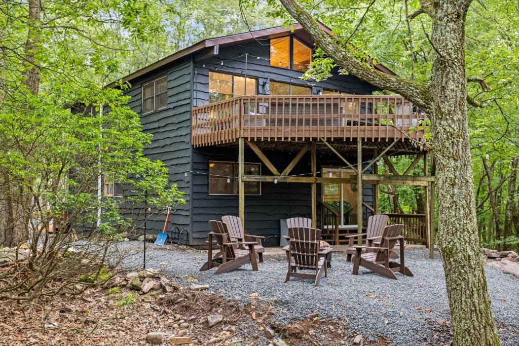 a cabin in the woods with chairs and a deck at Cabin in the Skye - 5 BDs Lake Harmony in Lake Harmony
