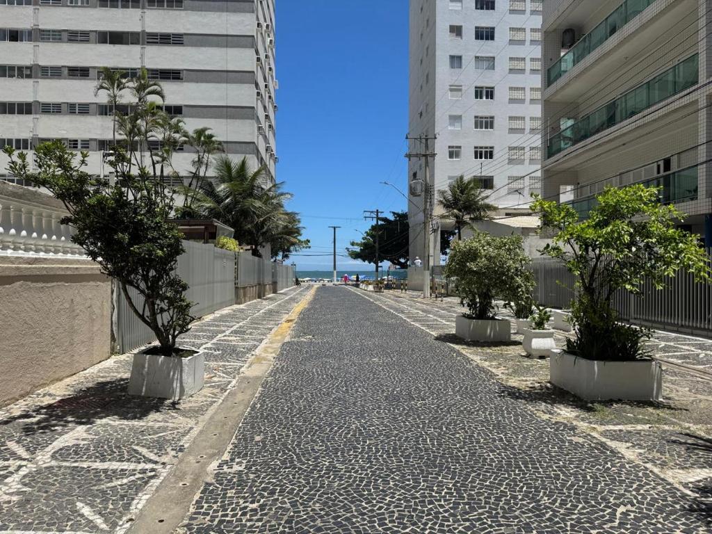 an empty street with palm trees and buildings at AP localização é tudo Pitangueiras in Guarujá
