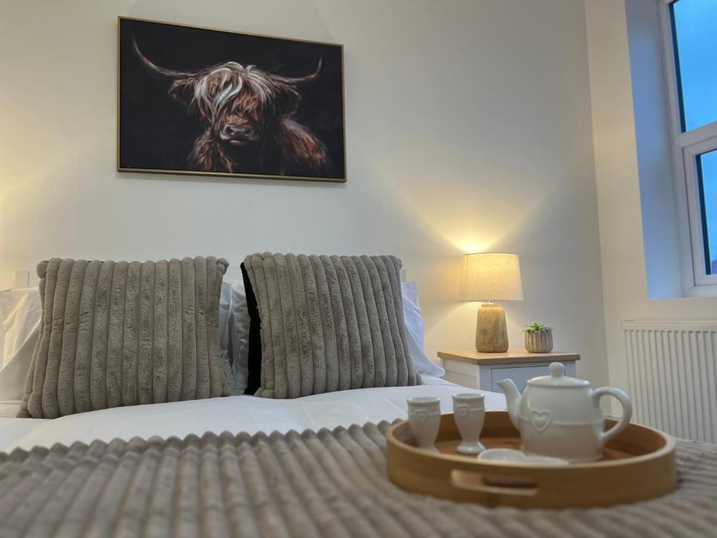 a bed with a tray with a tea set on it at Fully Refurbished 3 Bed Terraced House with Ensuite Central Rugby in Rugby