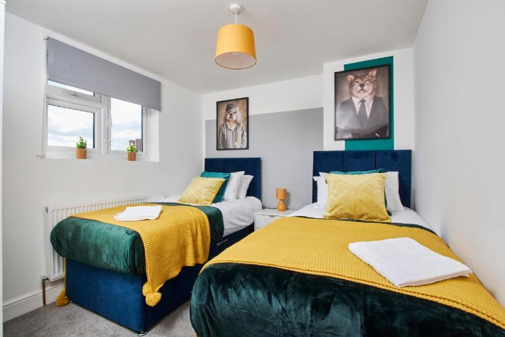 レッドブリッジにあるSleek Gem of London -2 Bedroom Apartment with Parkingのベッド2台が備わる小さな部屋のベッド2台