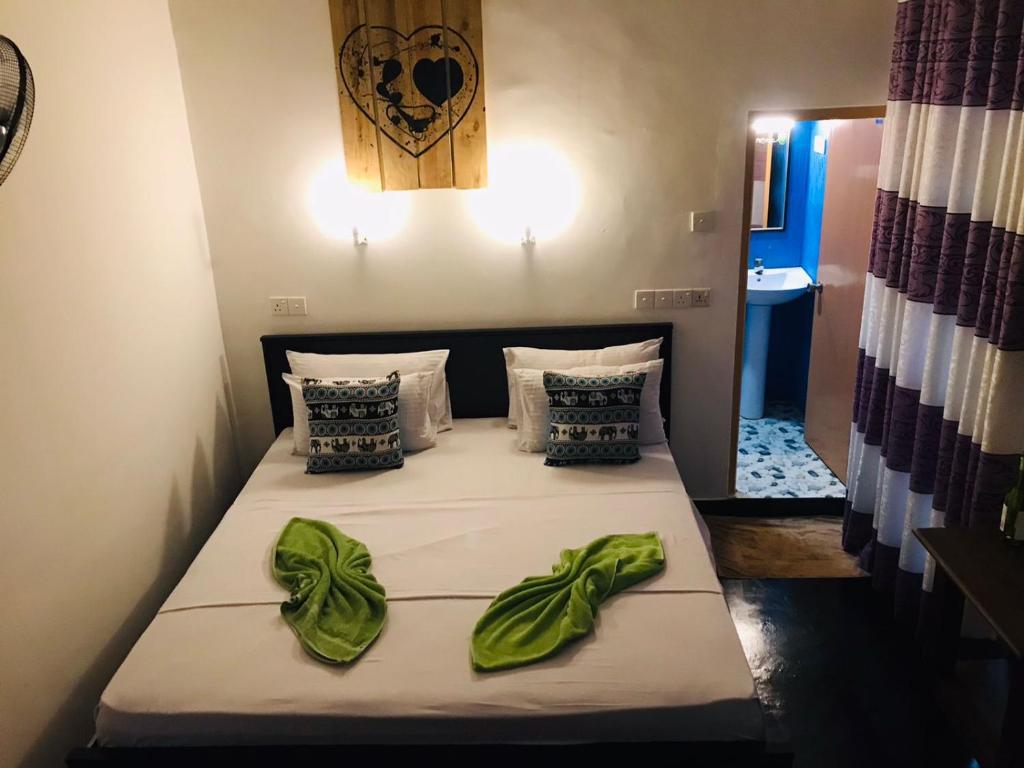 a bedroom with a bed with green leaves on it at Sh li in Sigiriya