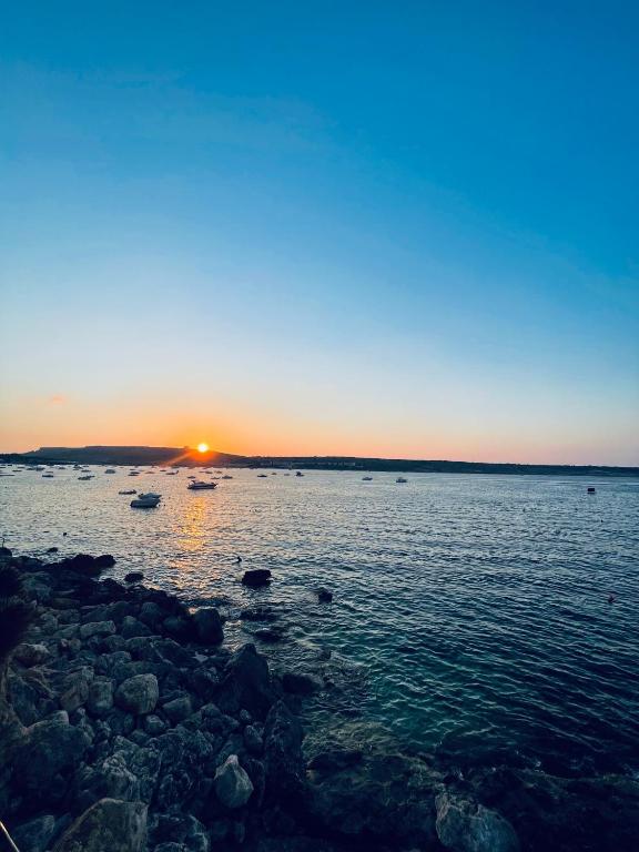 a sunset over a large body of water at Seafront Maisonette Ocean Views & Terrace in Mellieħa