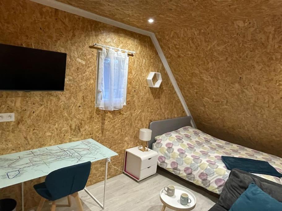 une chambre avec un lit, un bureau et une télévision dans l'établissement Chez GL, à Couilly-Pont-aux-Dames
