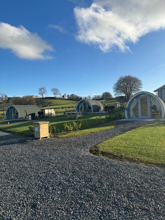 a view of a building with a grass field and a road at Knockmany View Glamping in Augher