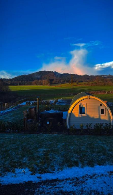 a large tent in a field with a sunset at Knockmany View Glamping in Augher