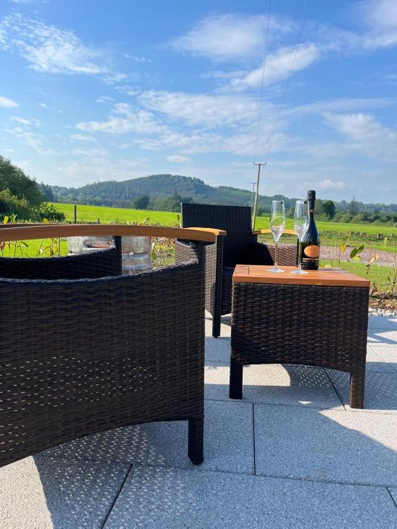 a table with a bottle of wine and a wine glass at Knockmany View Glamping in Augher