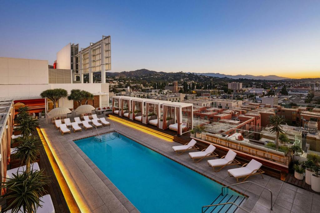 a swimming pool on top of a building with a city at W Hollywood in Los Angeles