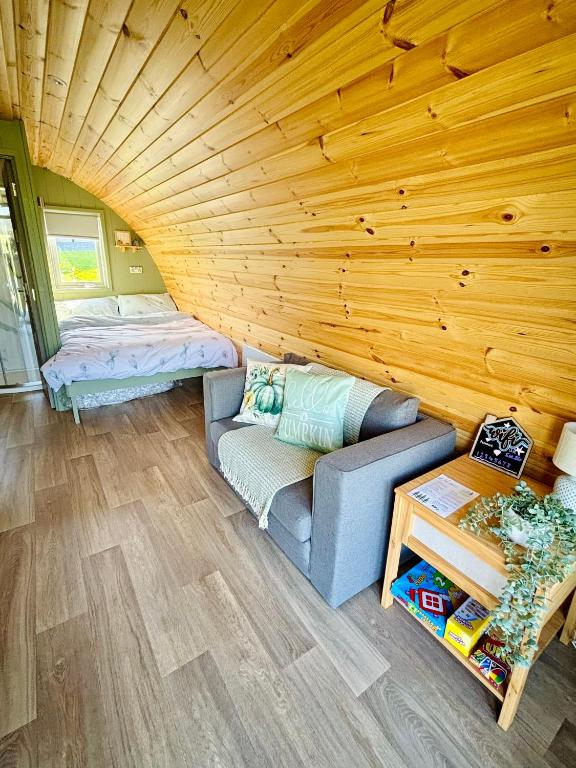 a living room with a couch and a bed at Knockmany View Glamping in Augher