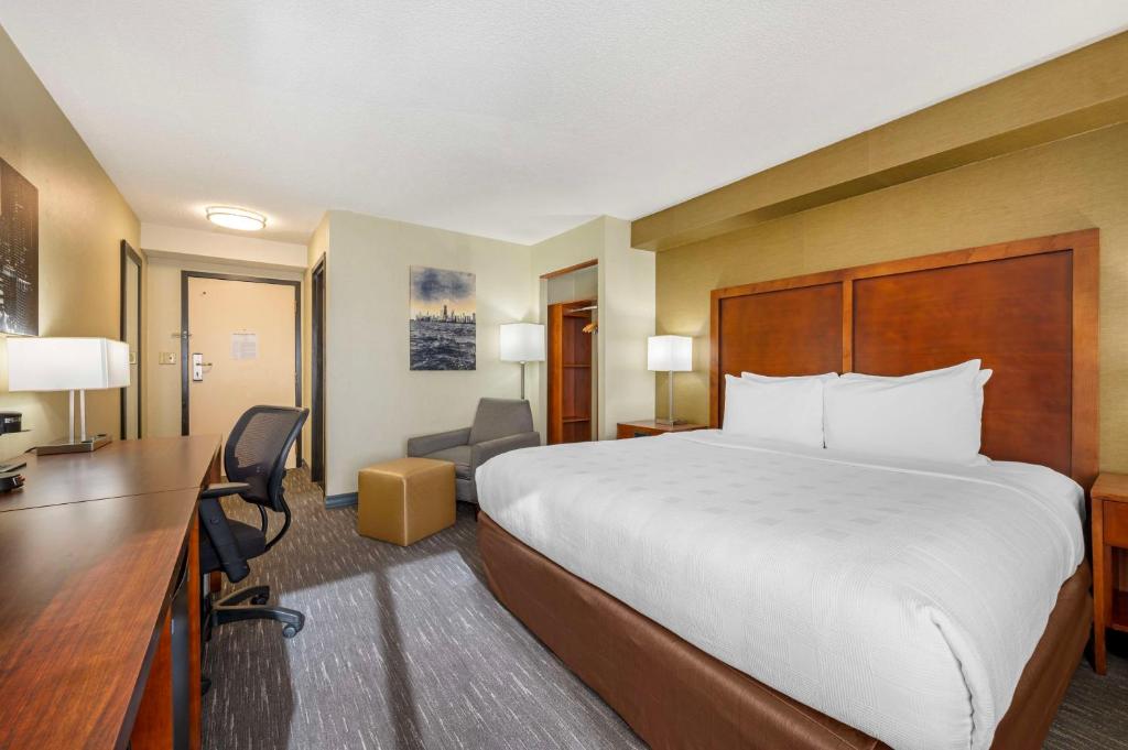 a hotel room with a large bed and a desk at Best Western Chicago - Downers Grove in Downers Grove