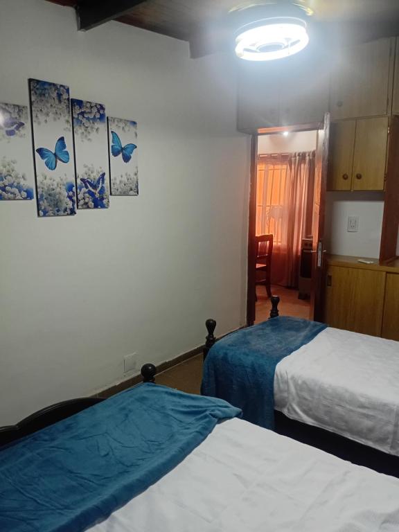 a room with two beds and a door to a kitchen at Punto Descanso in Corrientes