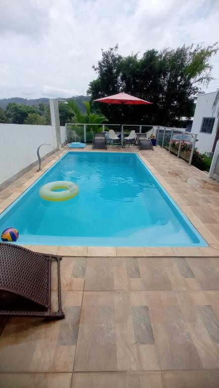 a large blue swimming pool with a frisbee in it at Pousada Paraíso das Águas Capitólio in Capitólio