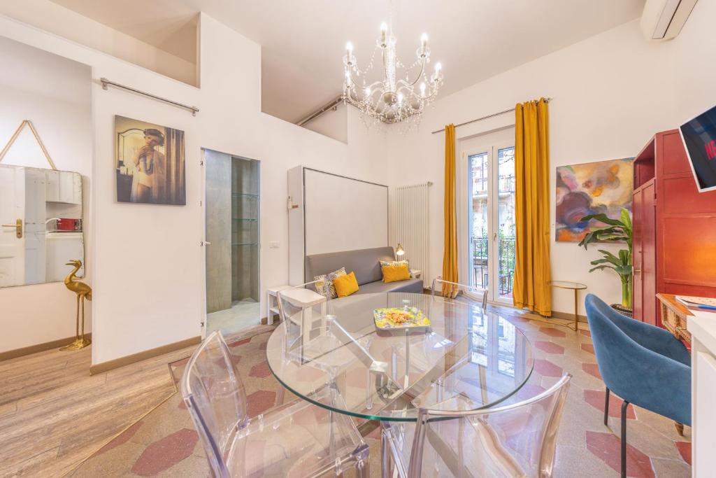 uma sala de estar com uma mesa de vidro e cadeiras azuis em La Vaticana - Saint Peters View - Apt Rome em Roma