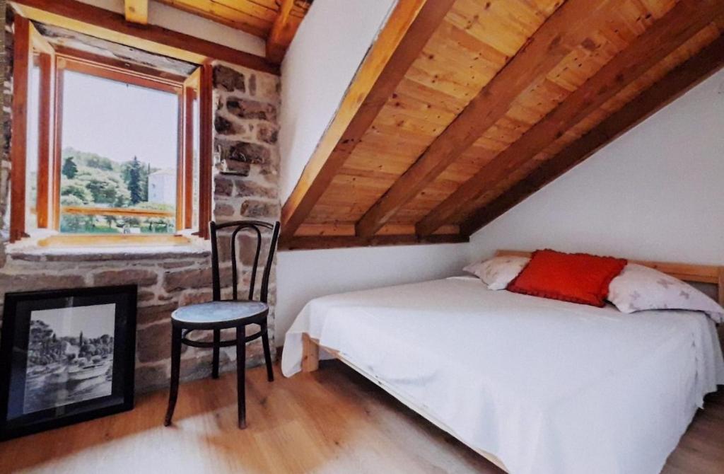 a bedroom with a bed and a chair and a window at Seaside holiday house Maslinica, Solta - 23838 in Grohote
