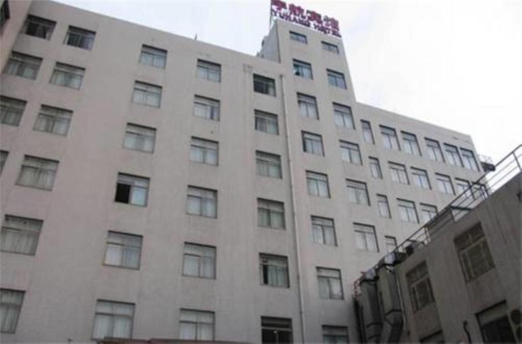 ein großes weißes Gebäude mit einem Schild darüber in der Unterkunft Shanghai YUHANG Hotel in Shanghai