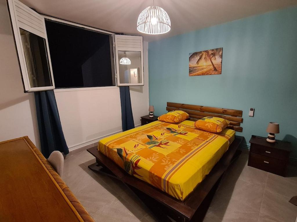 una camera da letto con un letto e una grande finestra di Villa Kasanaco avec vue sur la mer a Case-Pilote