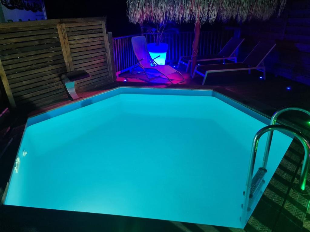 una piscina con illuminazione blu in un cortile posteriore di Villa Kasanaco avec vue sur la mer a Case-Pilote