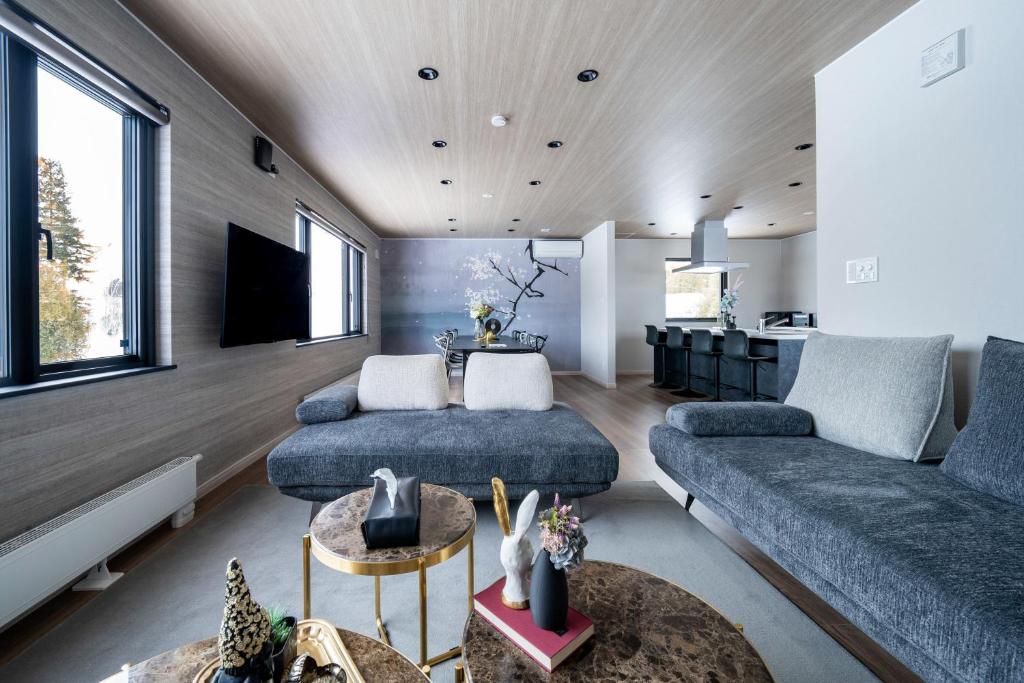 ein Wohnzimmer mit Sofa und Tisch in der Unterkunft THE Sakura in Kami-furano