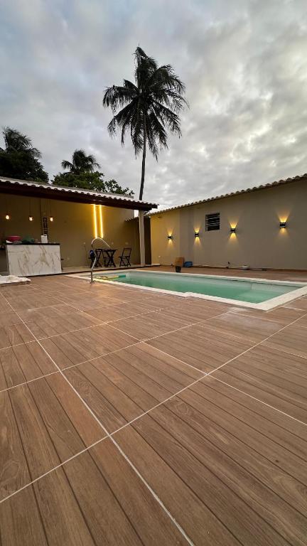 a tennis court in front of a building with a palm tree at Canto do Mangue in Cascavel