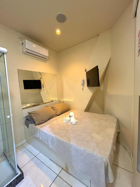 a small bedroom with a bed and a tv at Cine Rio Hostel RJ in Rio de Janeiro