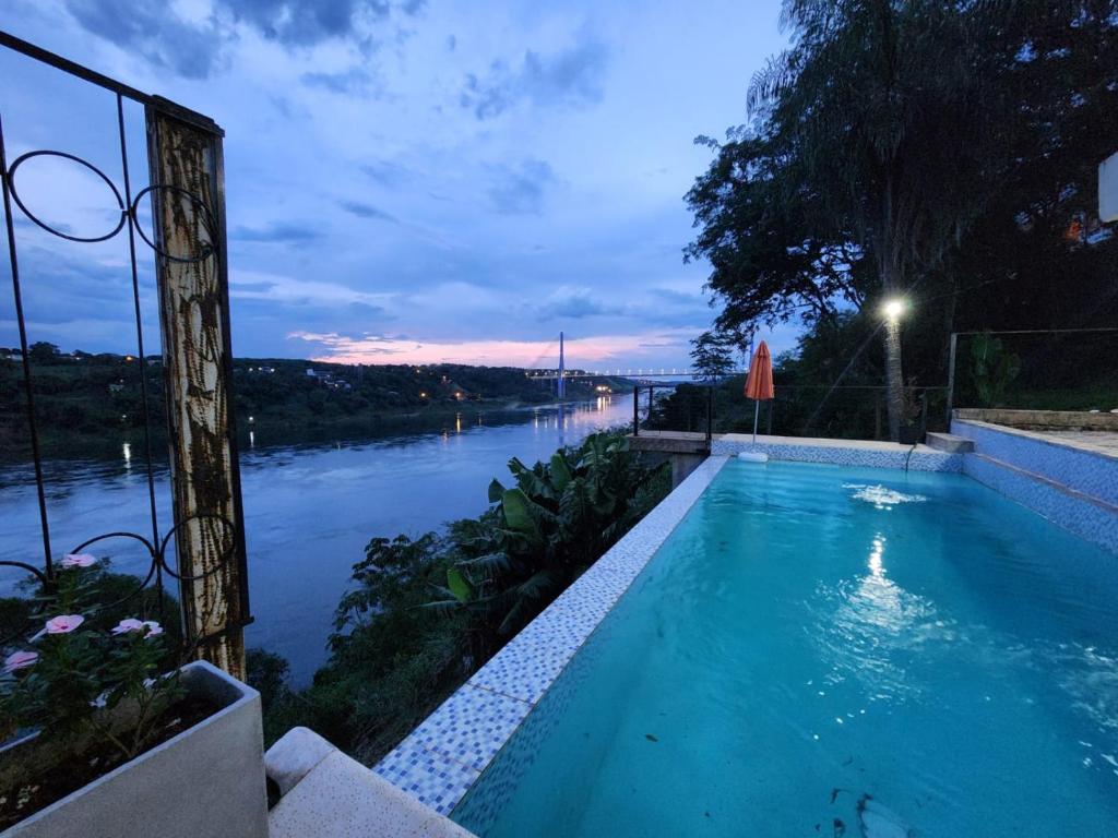 a swimming pool with a view of a river at La Frontera in Puerto Iguazú