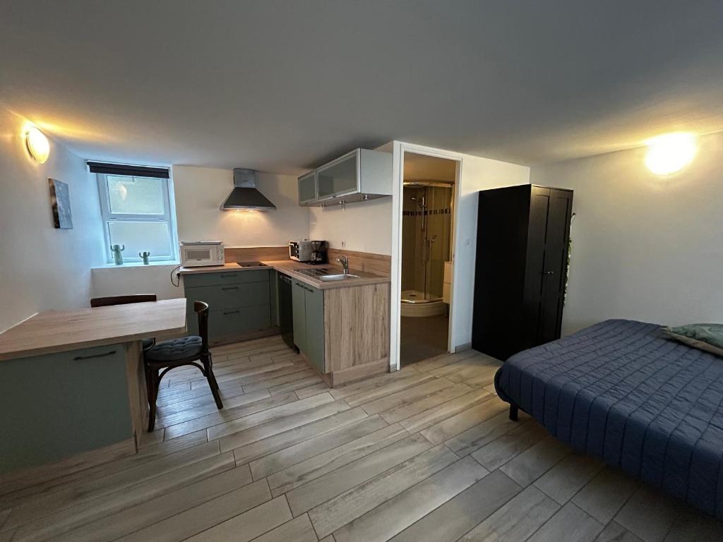 - une petite cuisine avec un lit et un bureau dans une chambre dans l'établissement Studio confort avec WiFi au centre de La Roche-Posay, proche Thermes, parking gratuit, 1-2 pers - FR-1-541-95, à La Roche-Posay