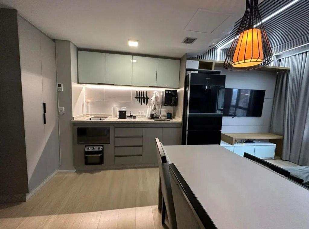 a kitchen with a white counter and a black refrigerator at Blend Smart Style, Setor Marista, Goiânia in Goiânia