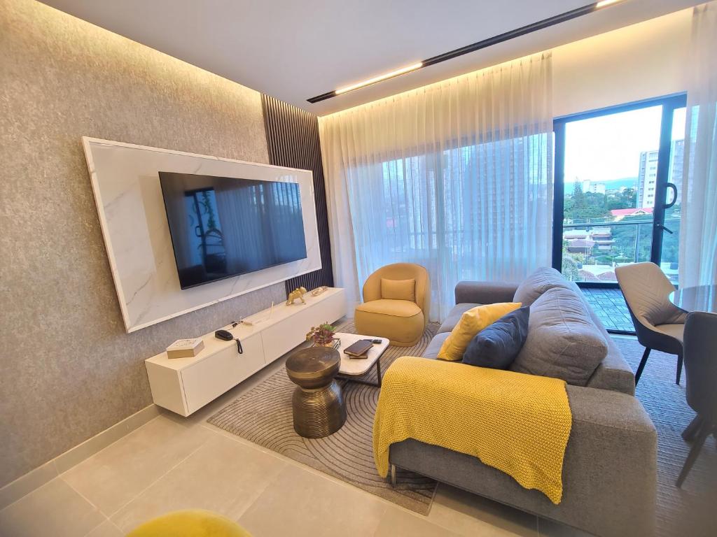 a living room with a couch and a television at Lujoso exclusivo próximo monumento in Santiago de los Caballeros