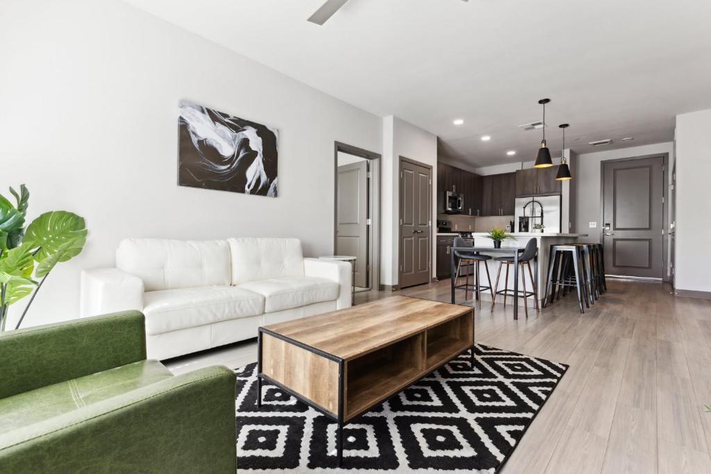 a living room with a white couch and a table at Cozysuites PHX RORO Gym Pool Pets Parking #18 in Phoenix
