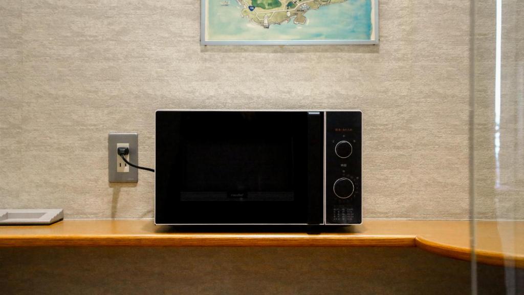 a microwave sitting on top of a wooden table at 熱海山荘 in Atami