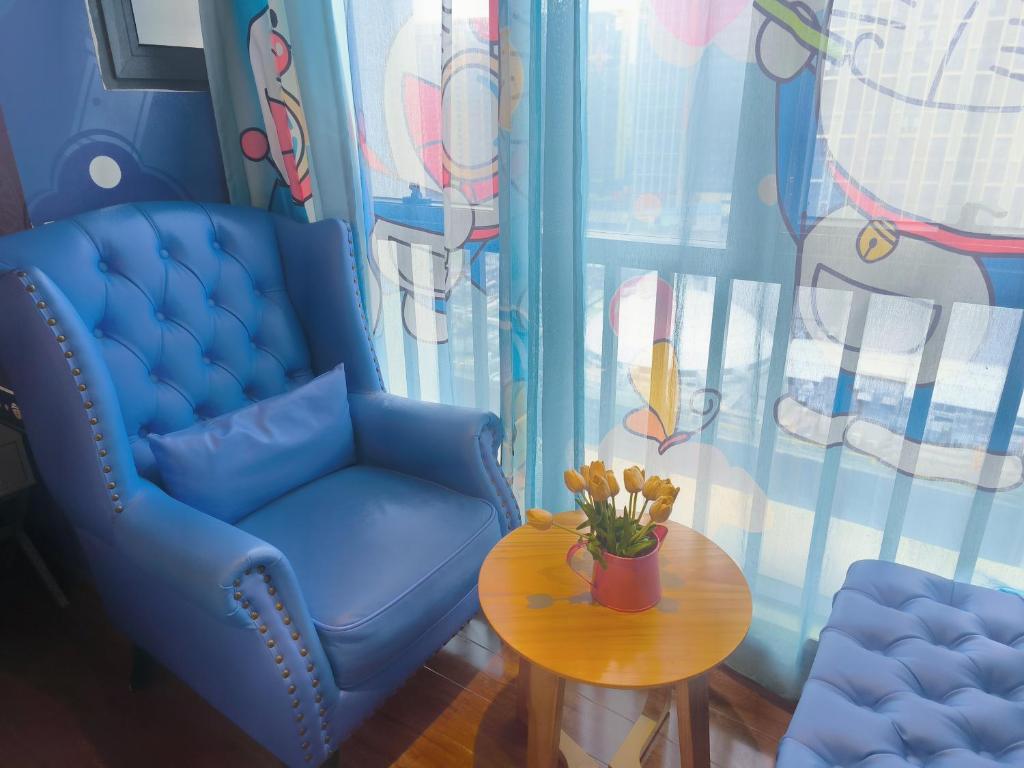 a room with a blue chair and a table at FRAGRANCE House Hanxi Changlong Panyu Wanda Plaza Store in Guangzhou