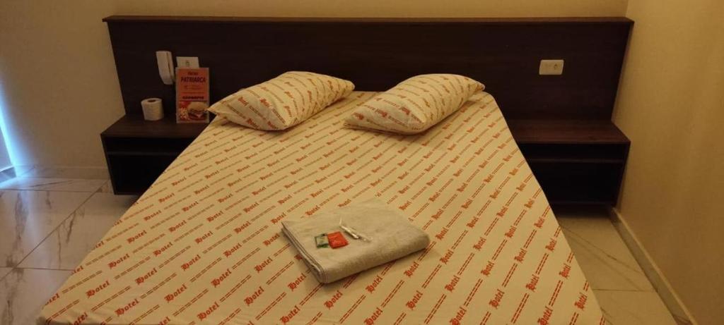 a bed with two pillows and a purse on it at Hotel Patriarca in Sao Paulo