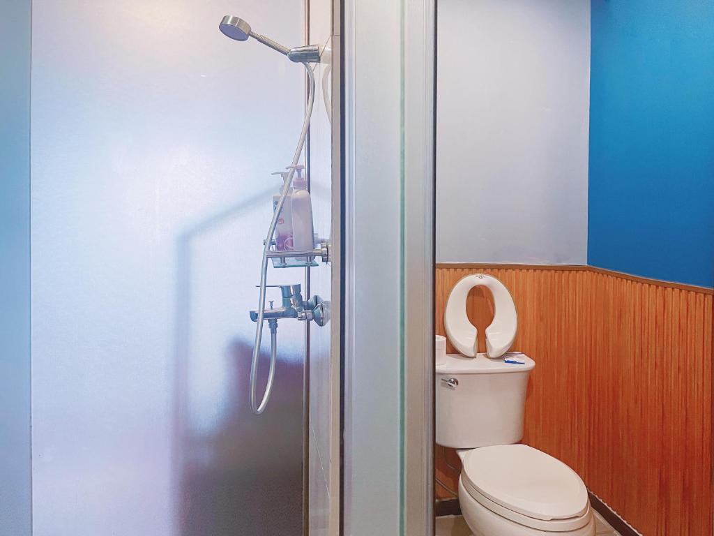 a bathroom with a shower with a toilet and a shower head at FRAGRANCE House Hanxi Changlong Panyu Wanda Plaza Store in Guangzhou