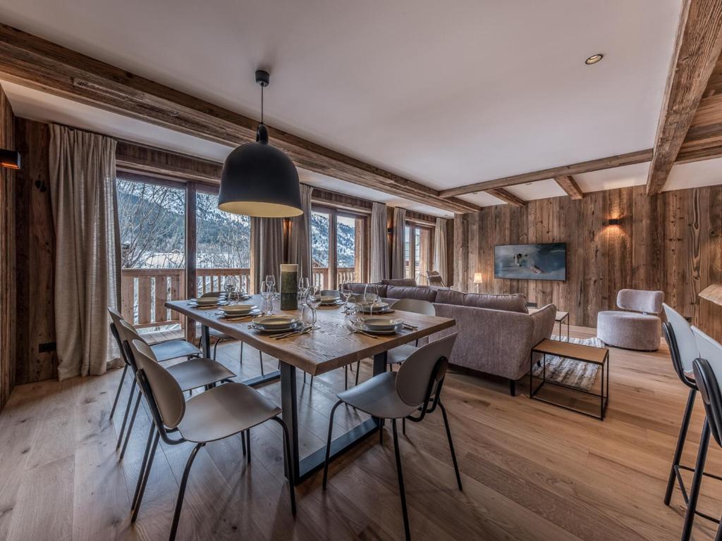 une salle à manger avec une table, des chaises et un canapé dans l'établissement Appartement de luxe pour 10 pers, terrasses, concierge, Méribel - FR-1-613-126, à Les Allues