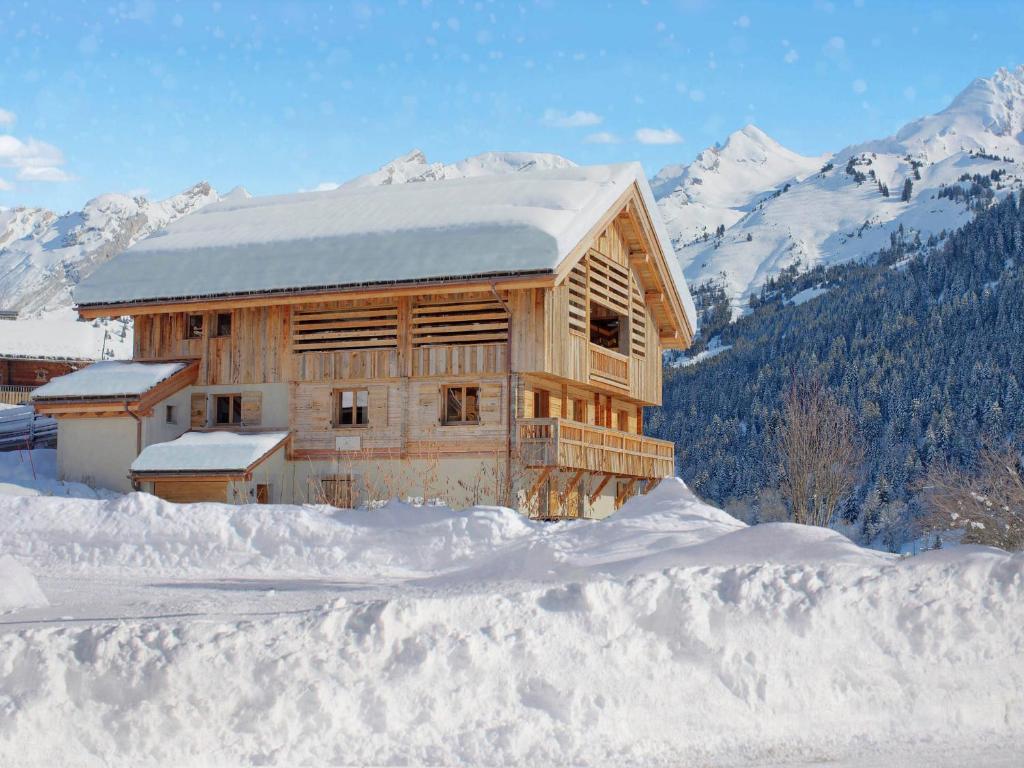 une cabane en bois dans la neige avec des montagnes enneigées dans l'établissement Chalet de luxe 5*, 15 pers., piscine, animaux admis, La Clusaz - FR-1-304-299, à La Clusaz