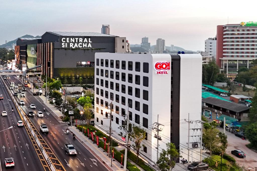 是拉差GO! Hotel Bowin at Robinson Lifestyle Bowin的城市街道上白色的建筑,上面有cgi标志