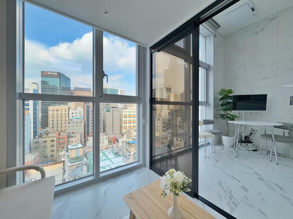 een woonkamer met grote ramen en uitzicht op een stad bij The Comfort in Seoul