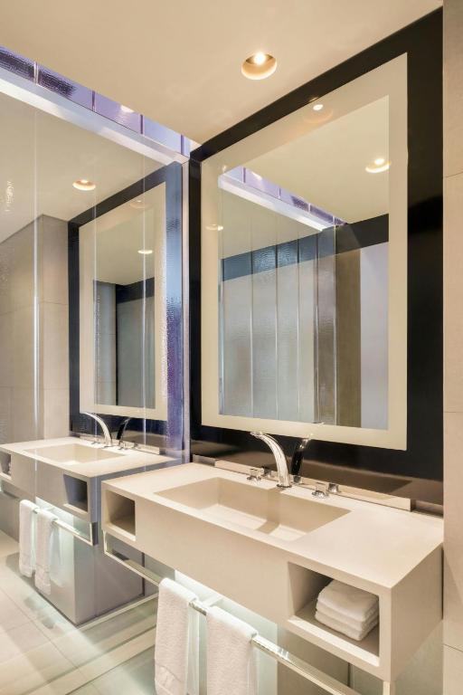 a bathroom with two sinks and two mirrors at W Bangkok Hotel in Bangkok