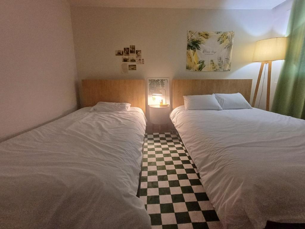two beds in a room with a checkered floor at Million House in Seoul