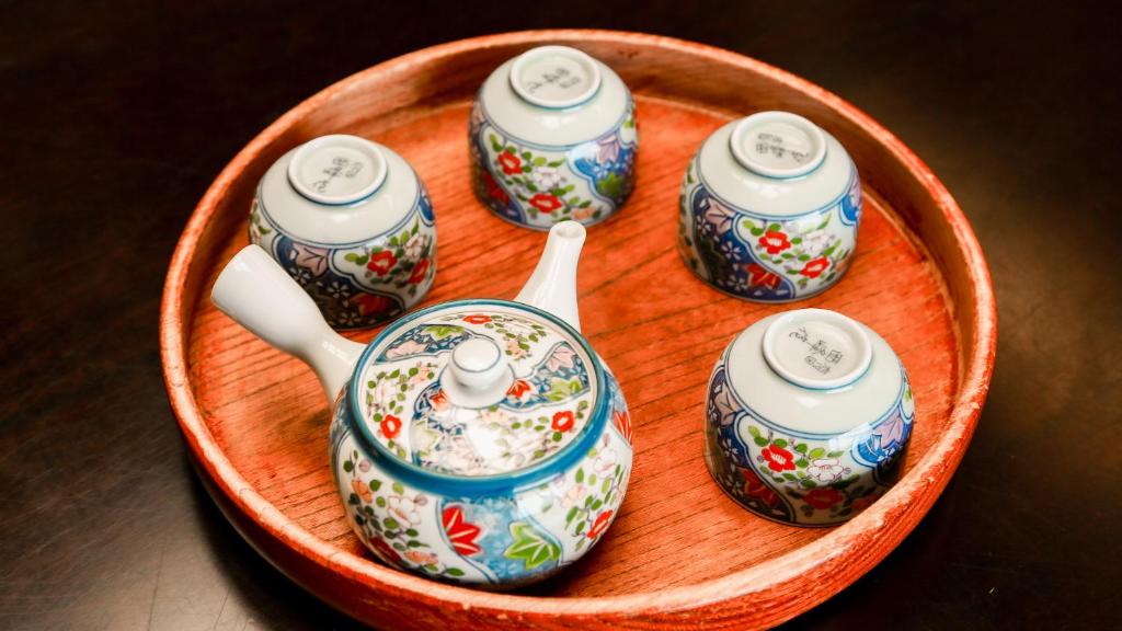 a group of teapots in a wooden bowl at 熱海山荘 in Atami